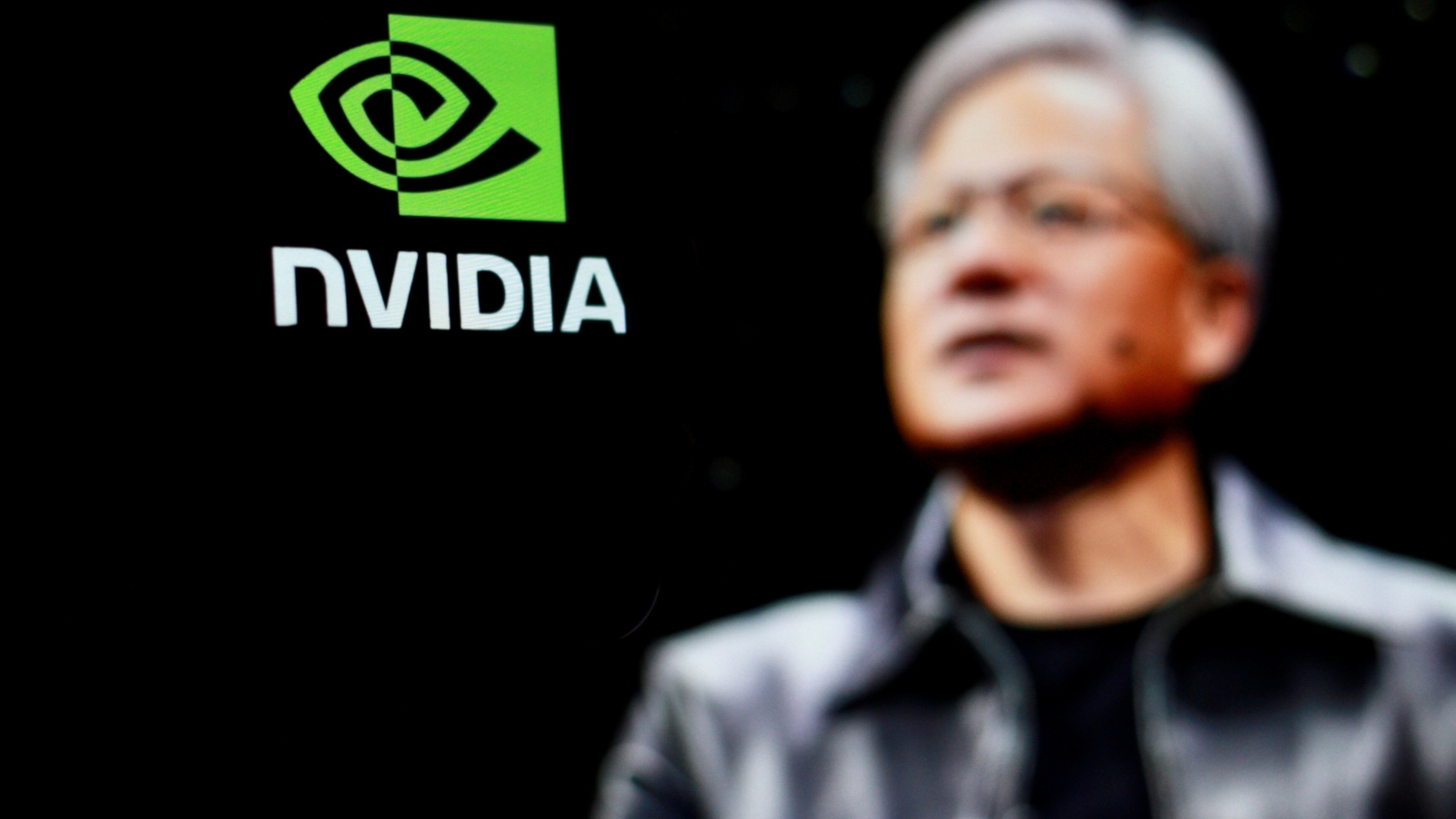 Nvidia CEO (Jensen Huang) in front of Nvidia logo